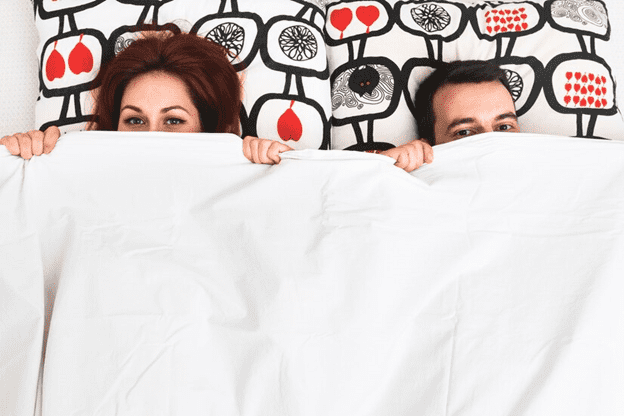 Couple tucked under the blankets