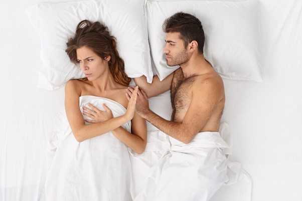 Woman refusing while laying in bed with a man