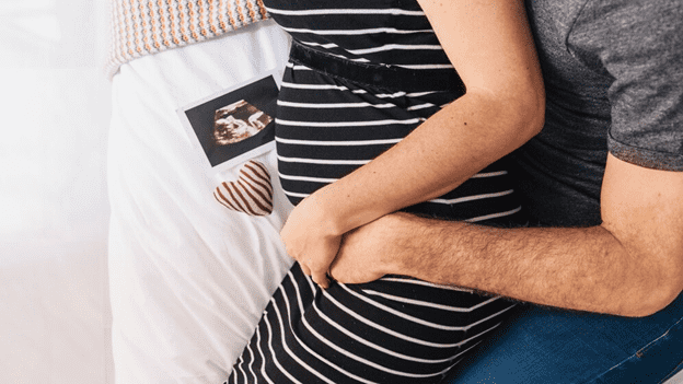 Pregnant couple holding each other