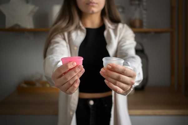 Woman holding two different coloured cups