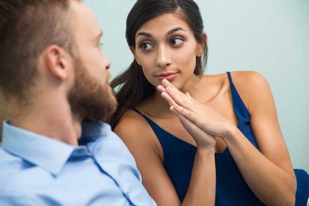 Woman sitting next to a man pleading